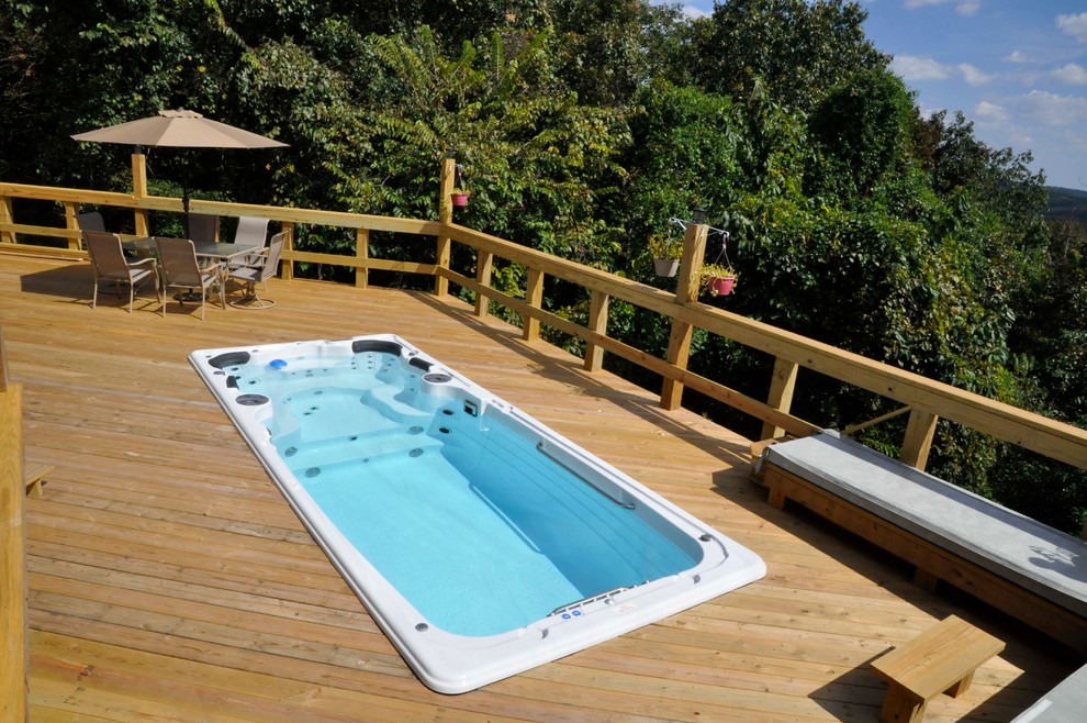 Idée de décoration pour une piscine sur toit chalet de taille moyenne et rectangle avec un bain bouillonnant et une terrasse en bois.
