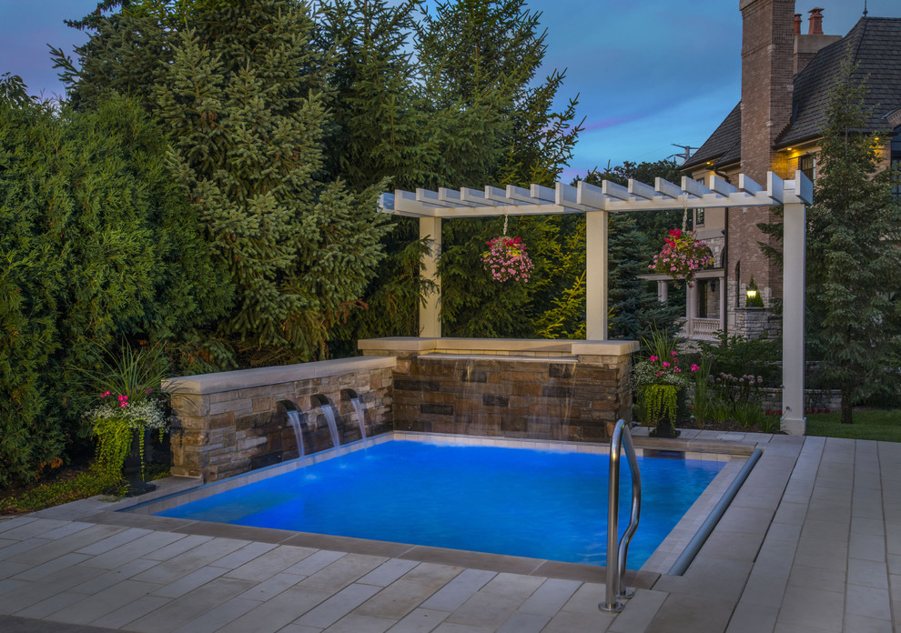 Diseño de piscinas y jacuzzis pequeños rectangulares en patio trasero con adoquines de piedra natural