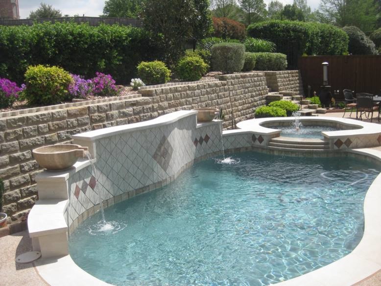 Ispirazione per una piscina naturale mediterranea personalizzata di medie dimensioni e dietro casa con una vasca idromassaggio e pedane
