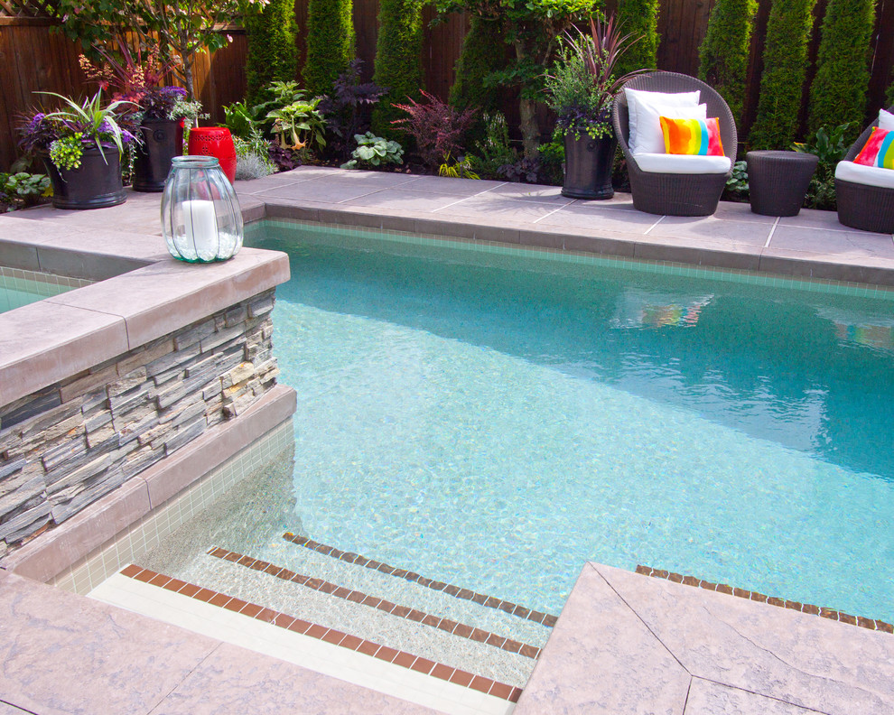Ispirazione per una piscina minimal personalizzata dietro casa con una vasca idromassaggio e cemento stampato