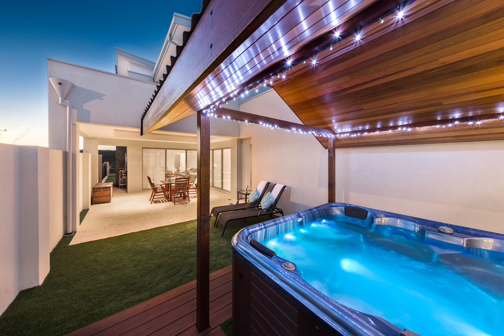 Small minimalist courtyard stamped concrete and rectangular aboveground hot tub photo in Perth