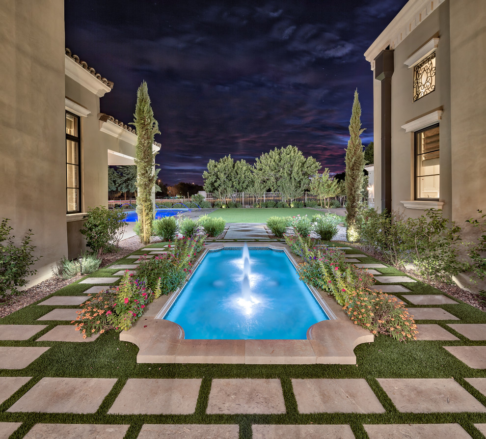 Ejemplo de piscina con fuente natural mediterránea grande a medida en patio trasero con adoquines de hormigón