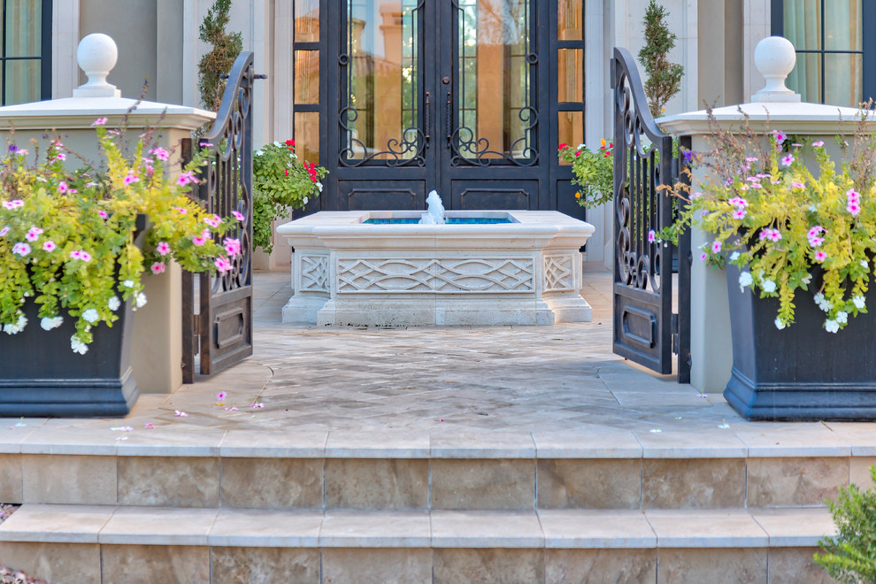 Источник вдохновения для домашнего уюта: большой естественный бассейн произвольной формы на заднем дворе в средиземноморском стиле с фонтаном и мощением тротуарной плиткой