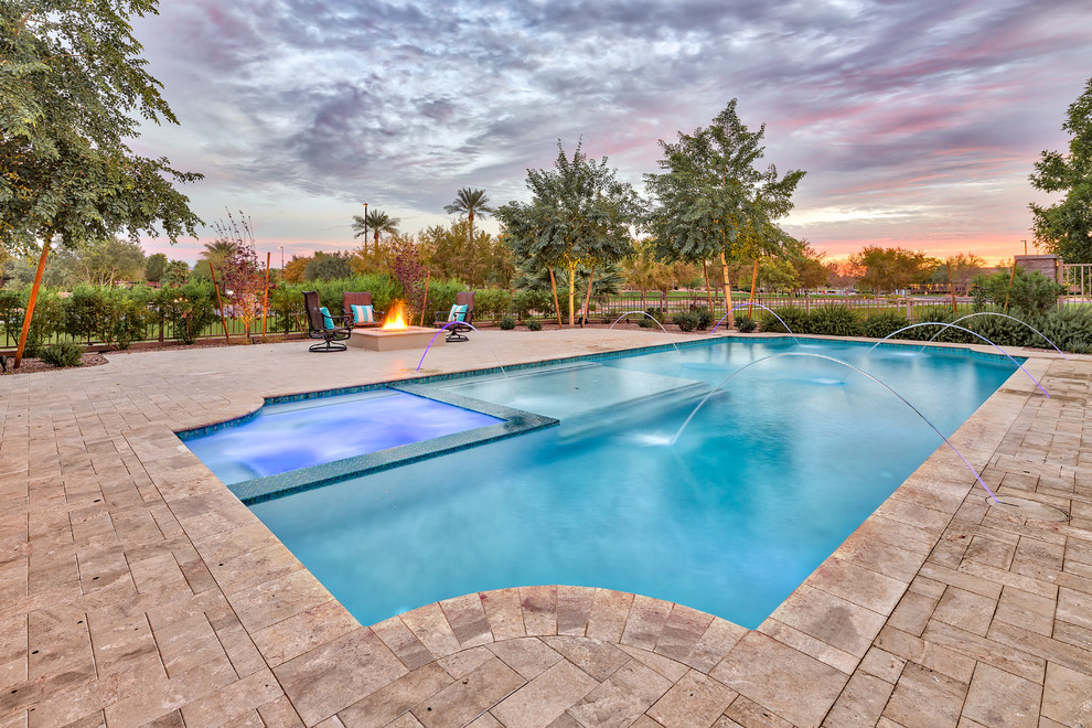 Diseño de piscina con fuente natural mediterránea grande a medida en patio trasero con adoquines de hormigón