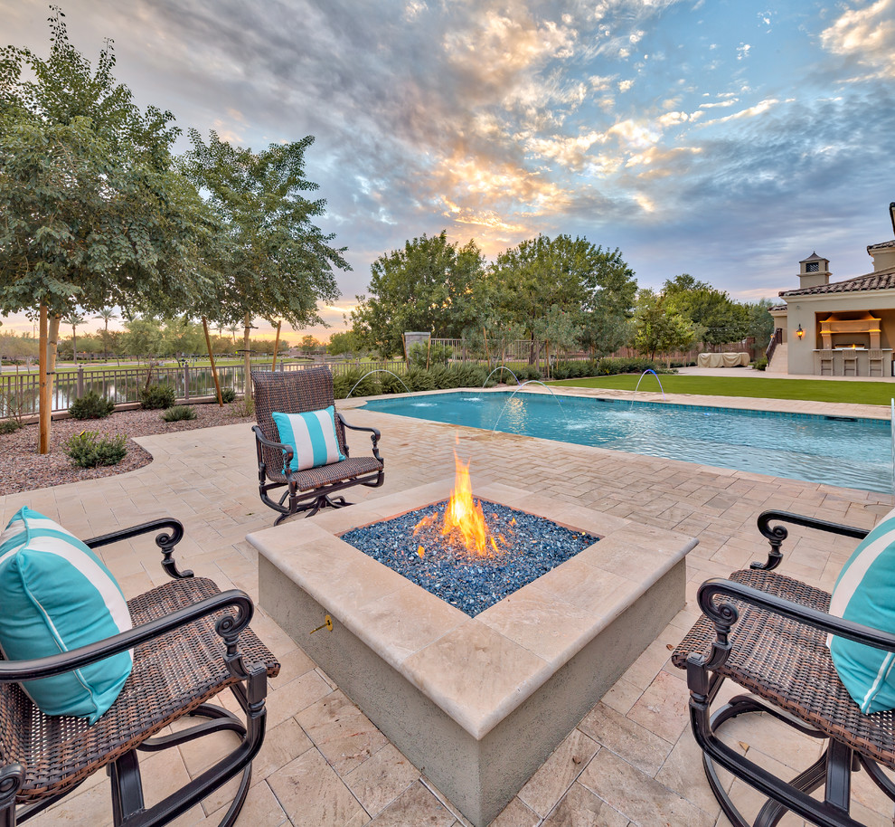 Example of a large tuscan backyard concrete paver and custom-shaped natural pool fountain design in Phoenix