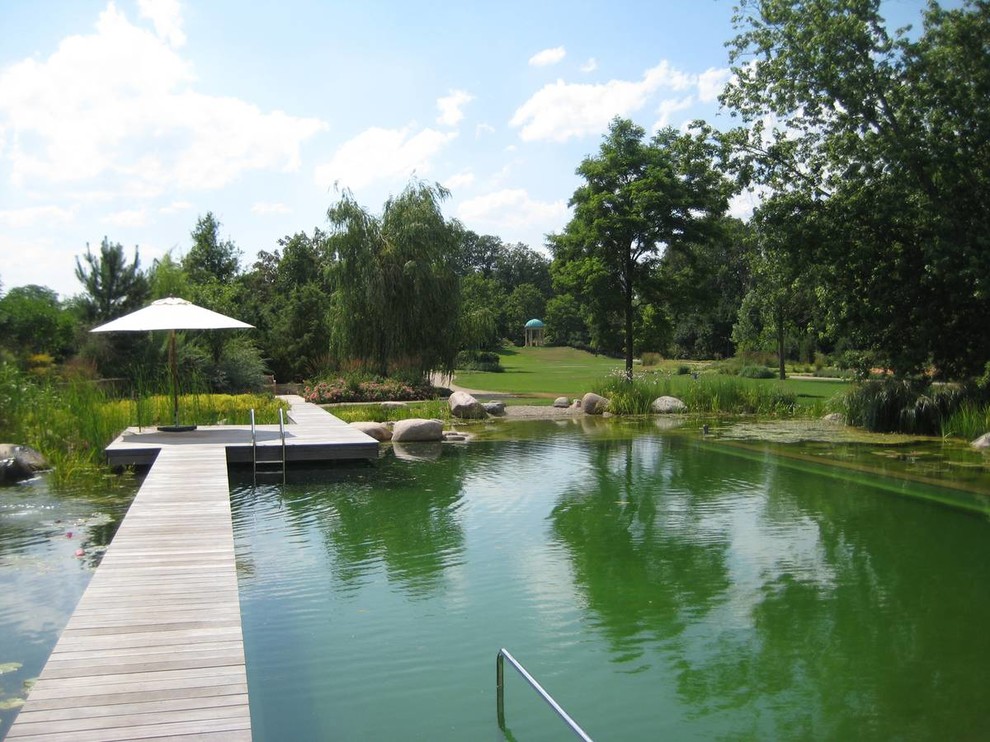 Inspiration for a huge cottage custom-shaped natural pool remodel in Berlin with decking