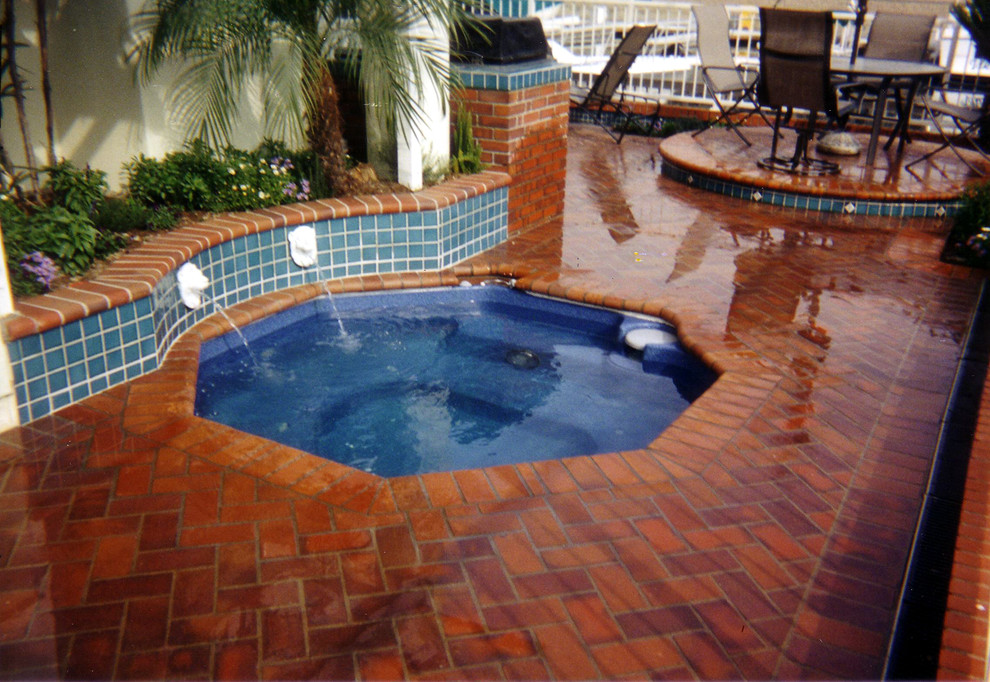 Foto de piscinas y jacuzzis actuales de tamaño medio rectangulares en patio trasero con adoquines de ladrillo