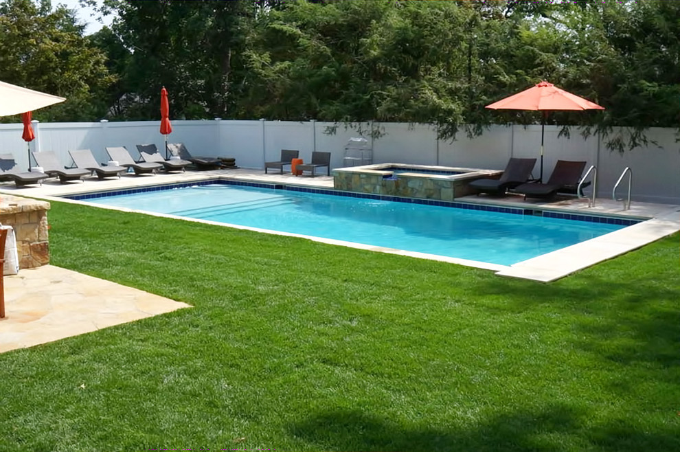 Idee per una grande piscina stile marino rettangolare dietro casa con fontane e pavimentazioni in cemento
