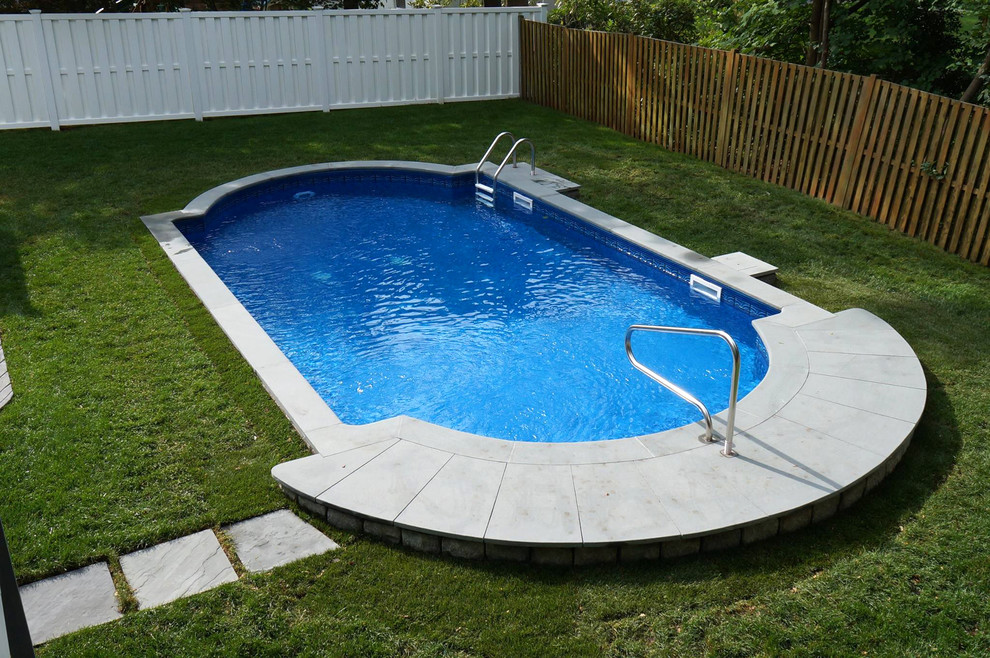Immagine di una piscina stile americano personalizzata di medie dimensioni e dietro casa con pavimentazioni in cemento