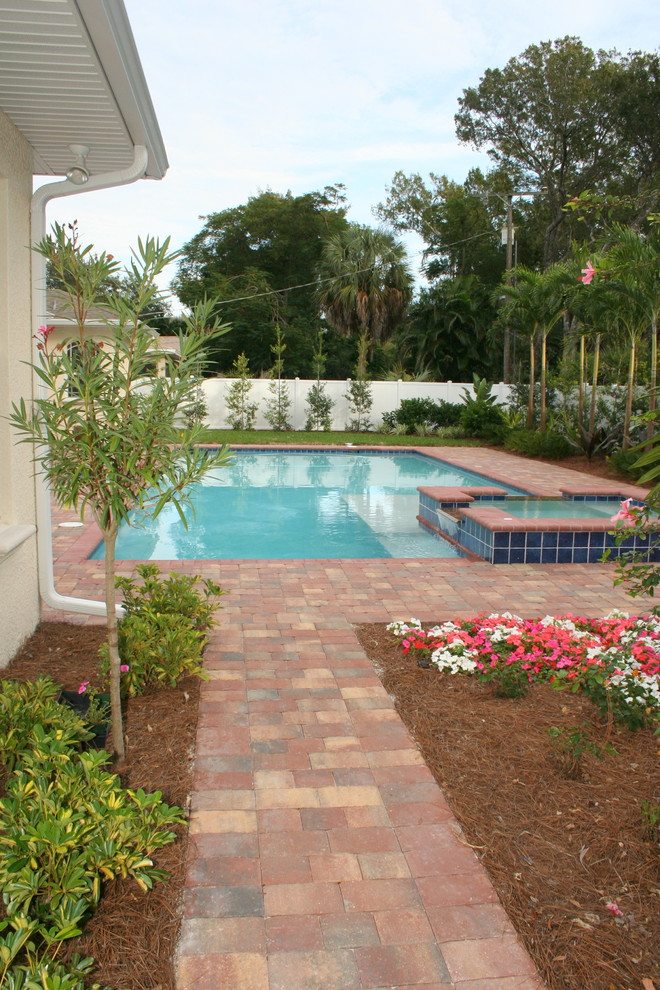 Foto de piscinas y jacuzzis exóticos de tamaño medio rectangulares en patio trasero con adoquines de ladrillo