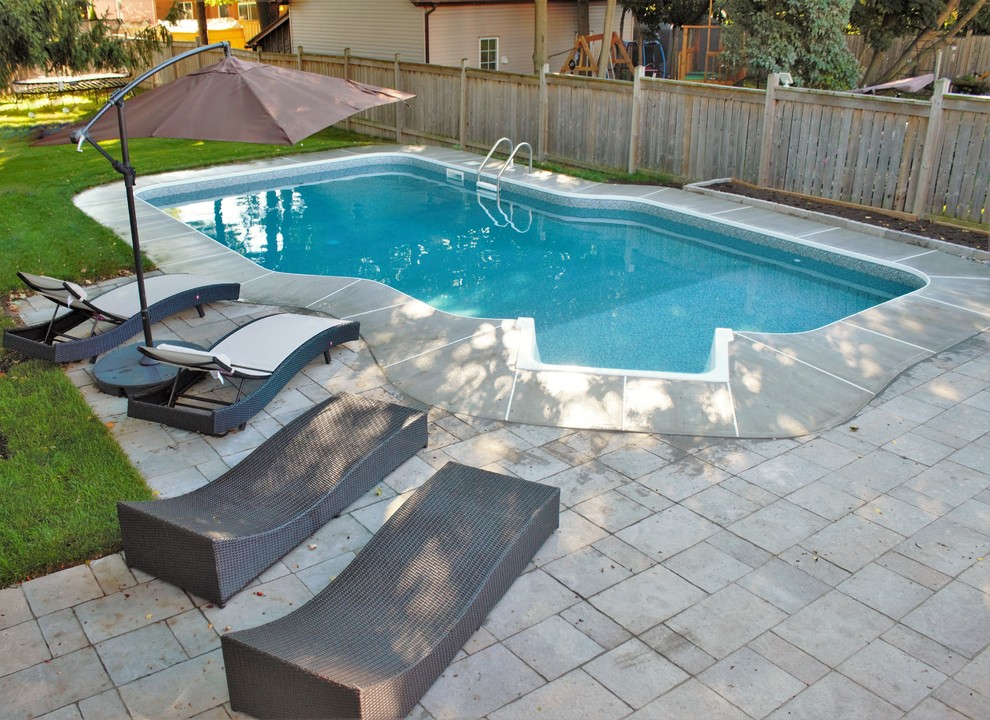 Inspiration for a mid-sized transitional backyard concrete paver and custom-shaped lap pool remodel in Toronto