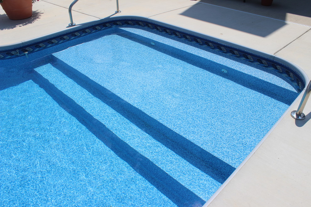 Idée de décoration pour une grande piscine arrière minimaliste avec du béton estampé.