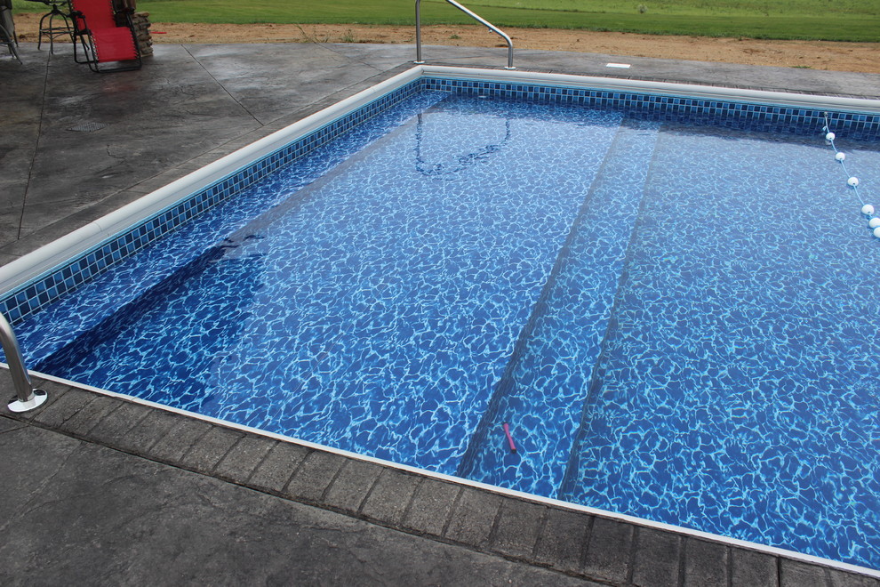 Idee per una grande piscina minimalista rettangolare dietro casa con cemento stampato