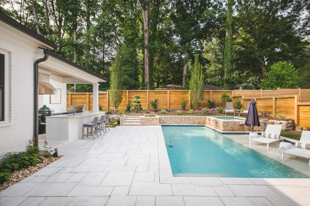 Immagine di una piscina tradizionale rettangolare dietro casa con una vasca idromassaggio e pavimentazioni in cemento