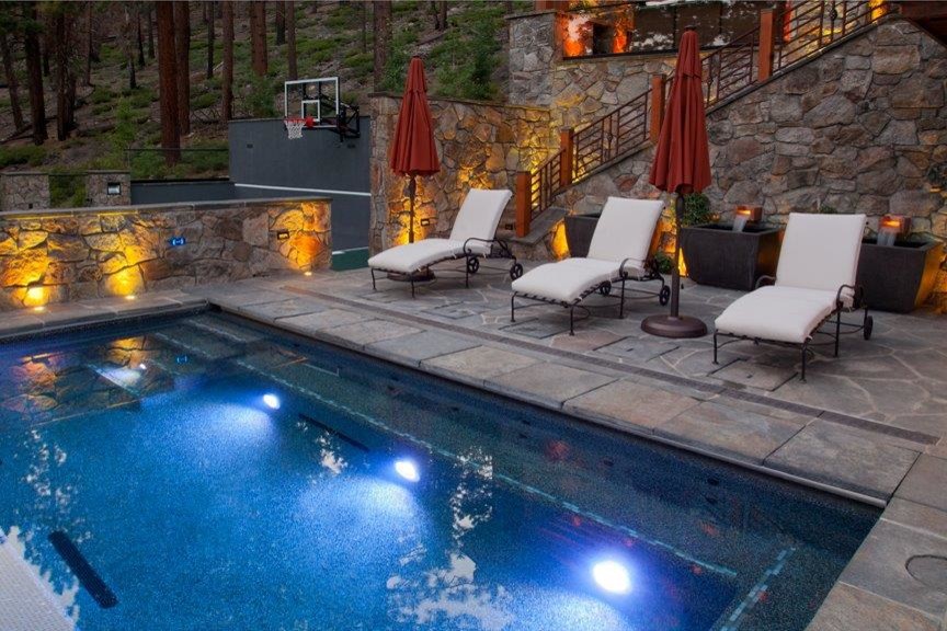 Imagen de piscina alargada de estilo americano pequeña rectangular en patio trasero con suelo de hormigón estampado