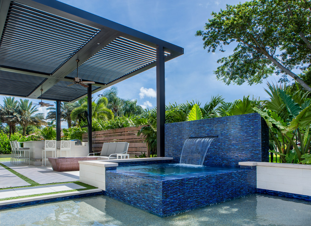 Ejemplo de piscinas y jacuzzis naturales contemporáneos grandes rectangulares en patio trasero con adoquines de hormigón