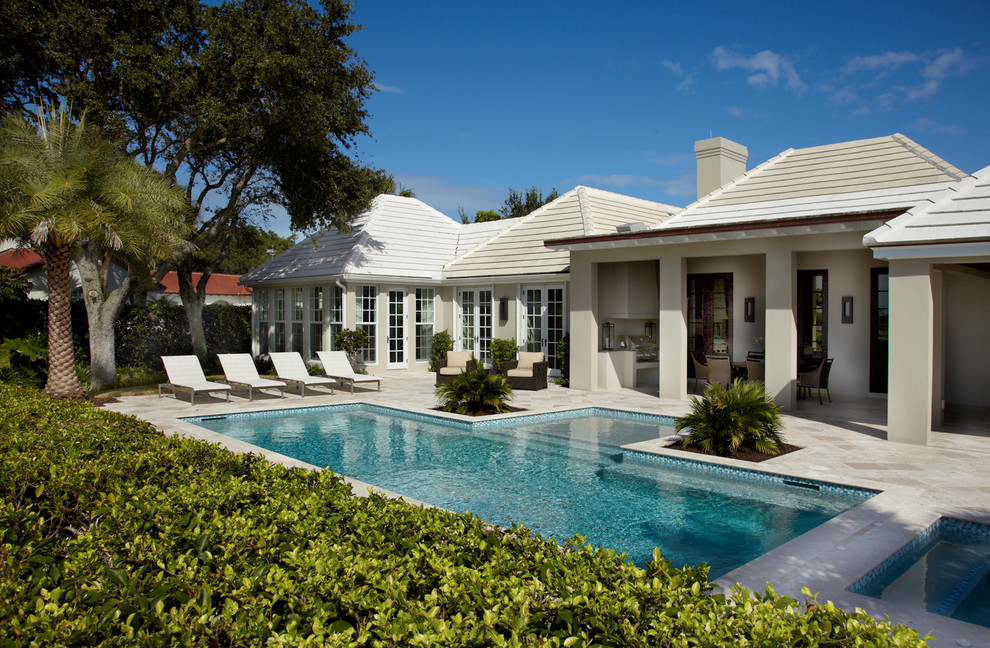 Ispirazione per una piscina classica personalizzata di medie dimensioni e dietro casa con pavimentazioni in pietra naturale e una vasca idromassaggio
