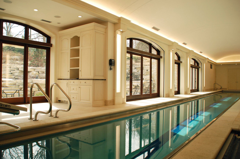 На фото: большой спортивный, прямоугольный бассейн в доме в классическом стиле с покрытием из плитки