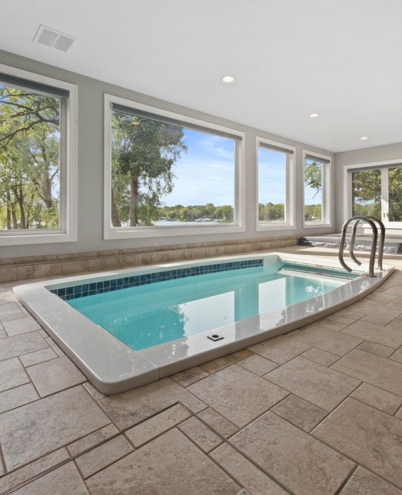 Exemple d'une grande piscine chic rectangle avec un bain bouillonnant et du carrelage.