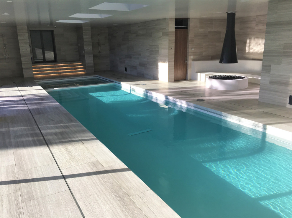 Idée de décoration pour une grande piscine intérieure rectangle avec des solutions pour vis-à-vis.