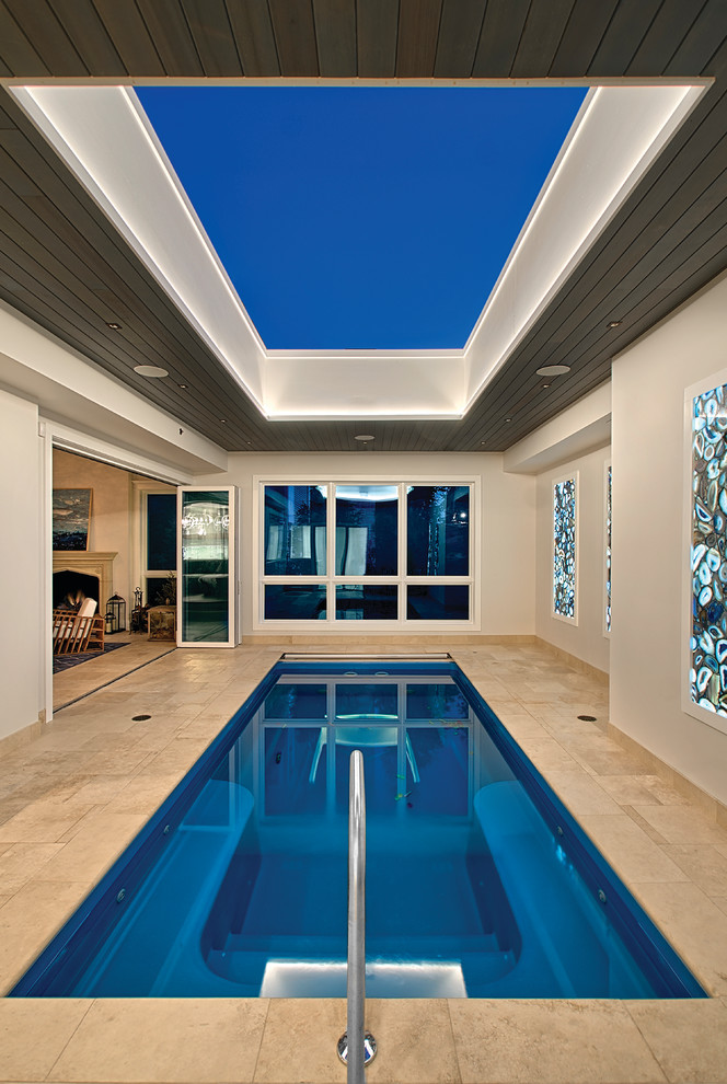 На фото: спортивный, прямоугольный бассейн среднего размера в доме в современном стиле с перегородкой для приватности и покрытием из каменной брусчатки с