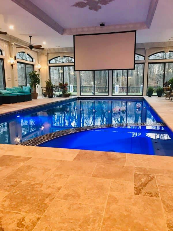 Imagen de piscina vintage grande interior y rectangular con adoquines de piedra natural