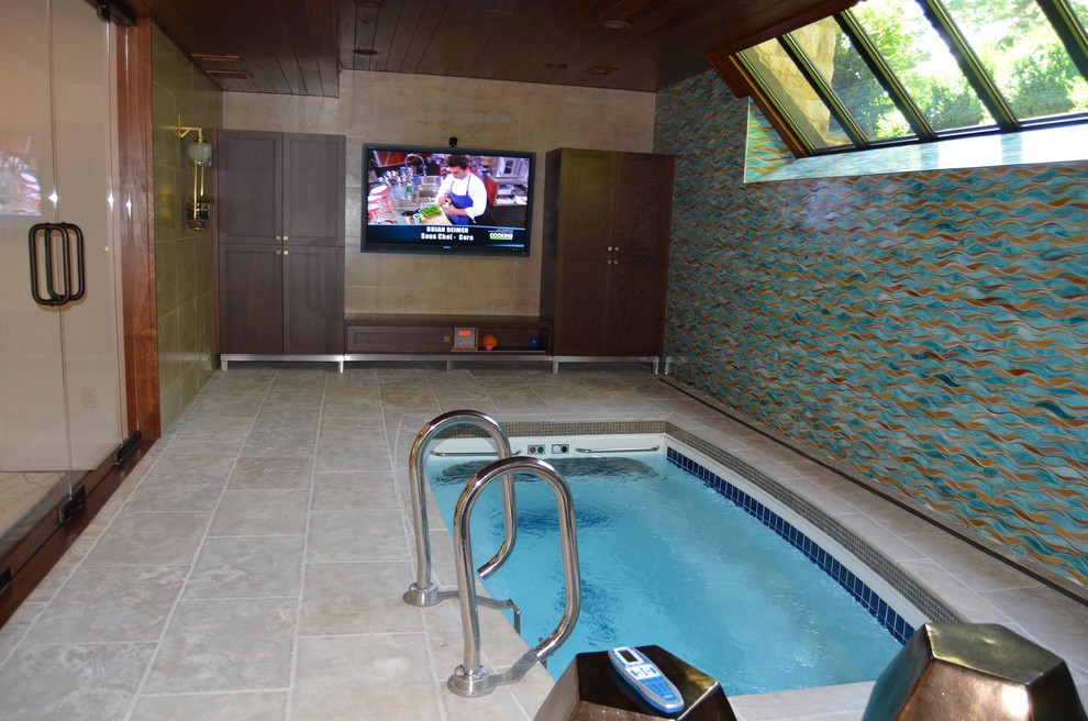 Medium sized contemporary indoor custom shaped hot tub in New York with concrete paving.