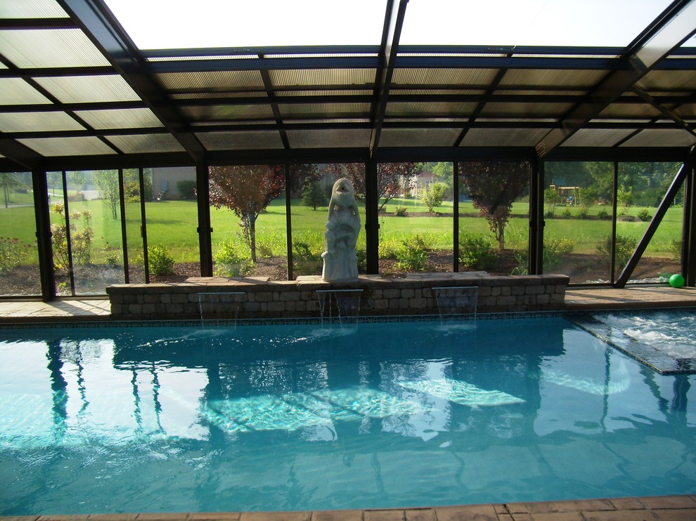 Diseño de piscina con fuente tradicional rectangular y interior con suelo de hormigón estampado