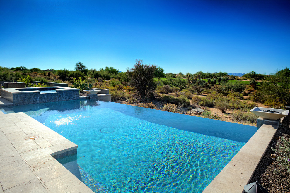 Idee per una piscina a sfioro infinito design rettangolare di medie dimensioni e dietro casa con una vasca idromassaggio