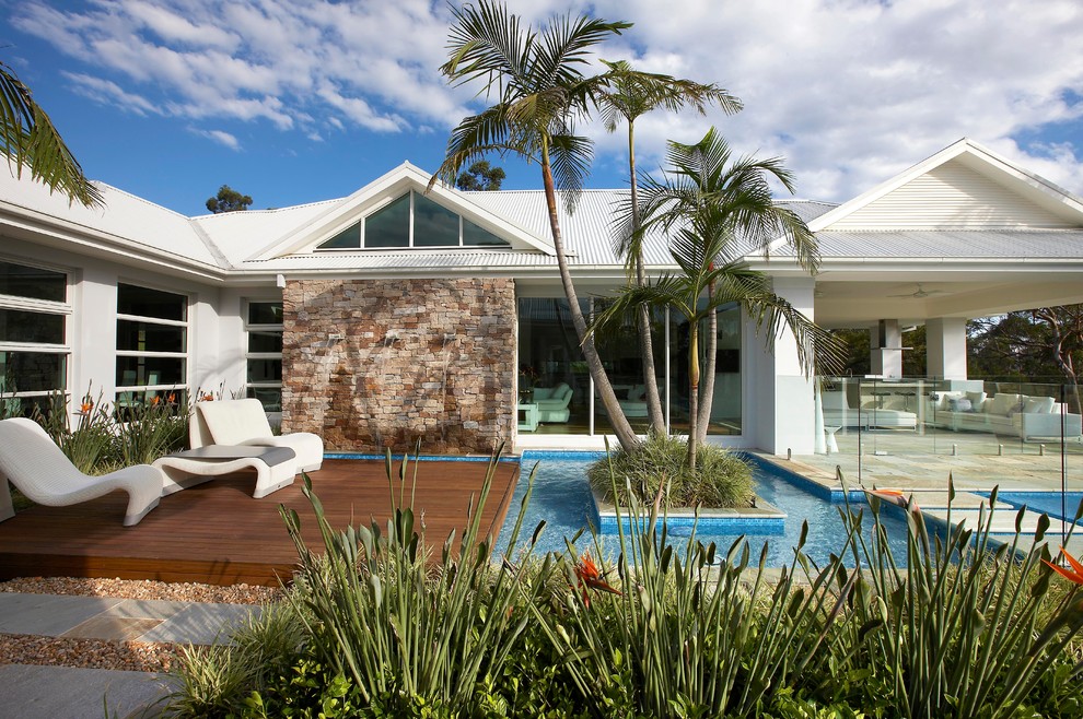Inspiration pour une piscine design avec une terrasse en bois.