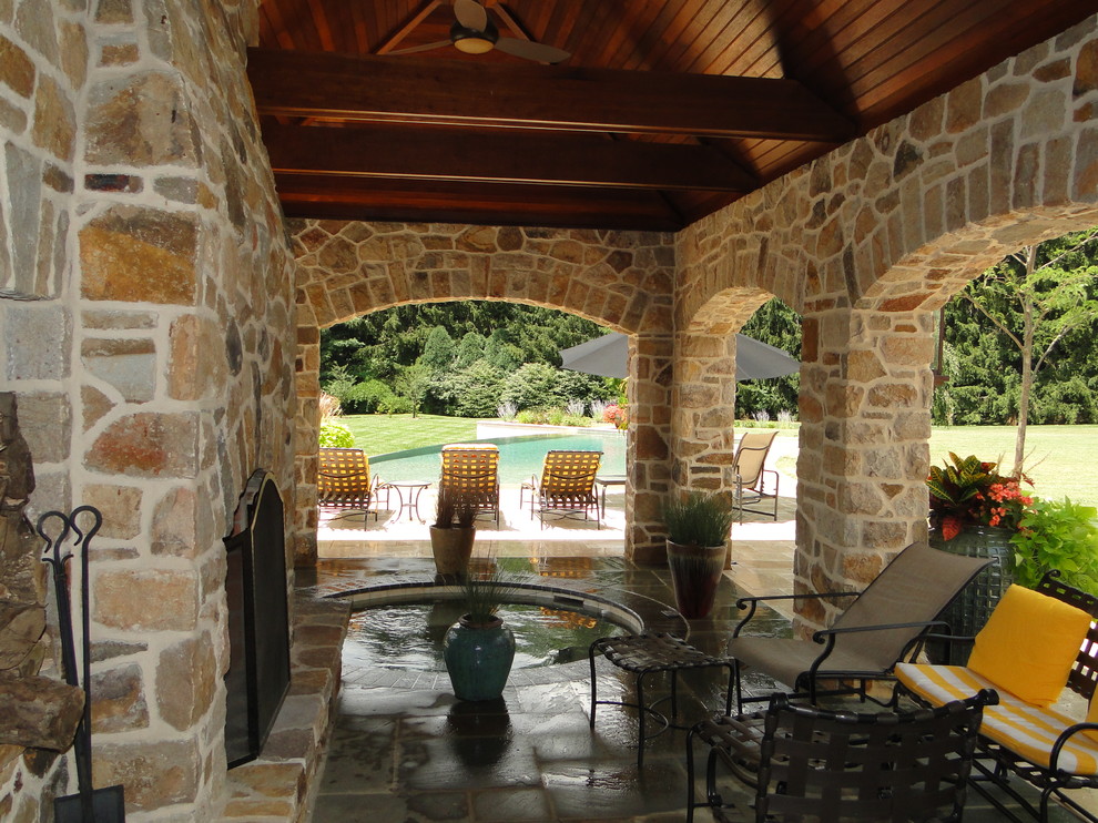 Пример оригинального дизайна: большой бассейн-инфинити произвольной формы на заднем дворе в классическом стиле с покрытием из каменной брусчатки и домиком у бассейна