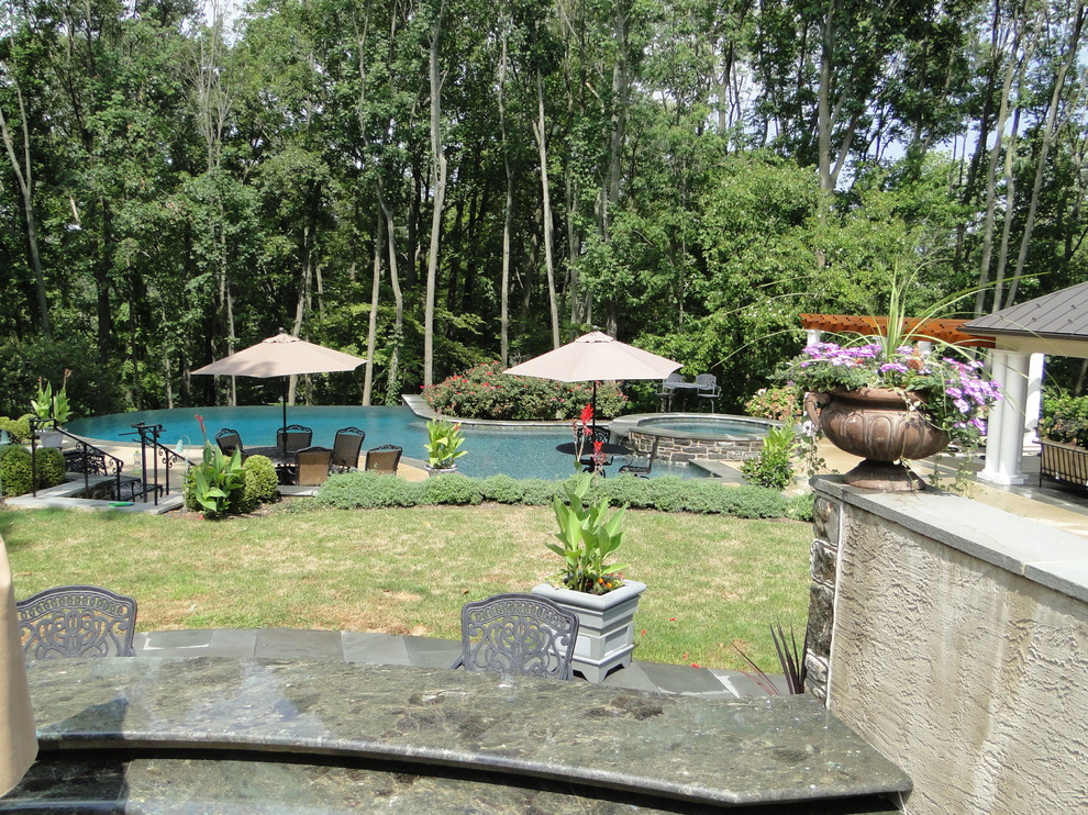 Ispirazione per una grande piscina monocorsia design personalizzata dietro casa con fontane e lastre di cemento