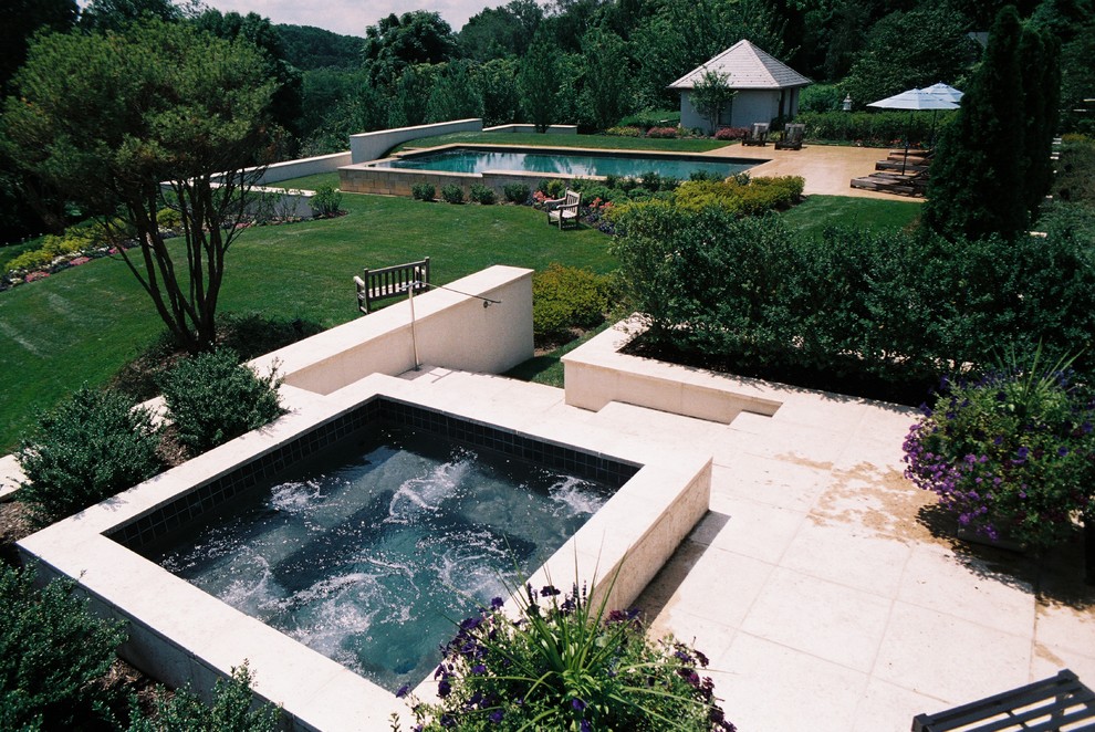 Hot tub - large traditional backyard stone and rectangular infinity hot tub idea in Philadelphia