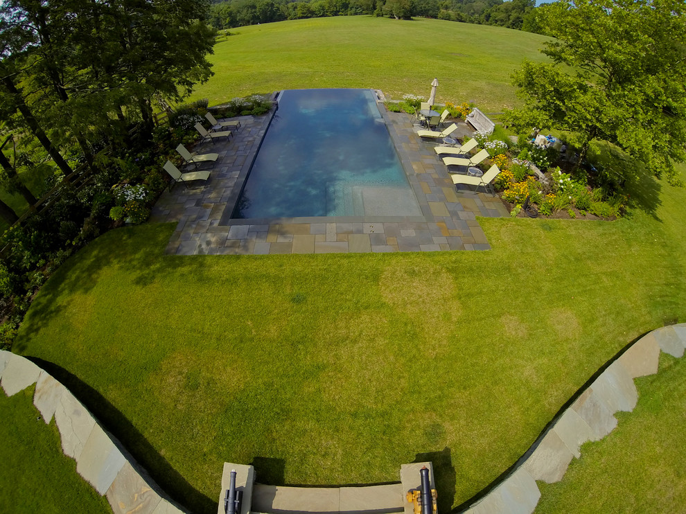 Источник вдохновения для домашнего уюта: большой прямоугольный бассейн-инфинити на заднем дворе в классическом стиле с фонтаном и покрытием из каменной брусчатки