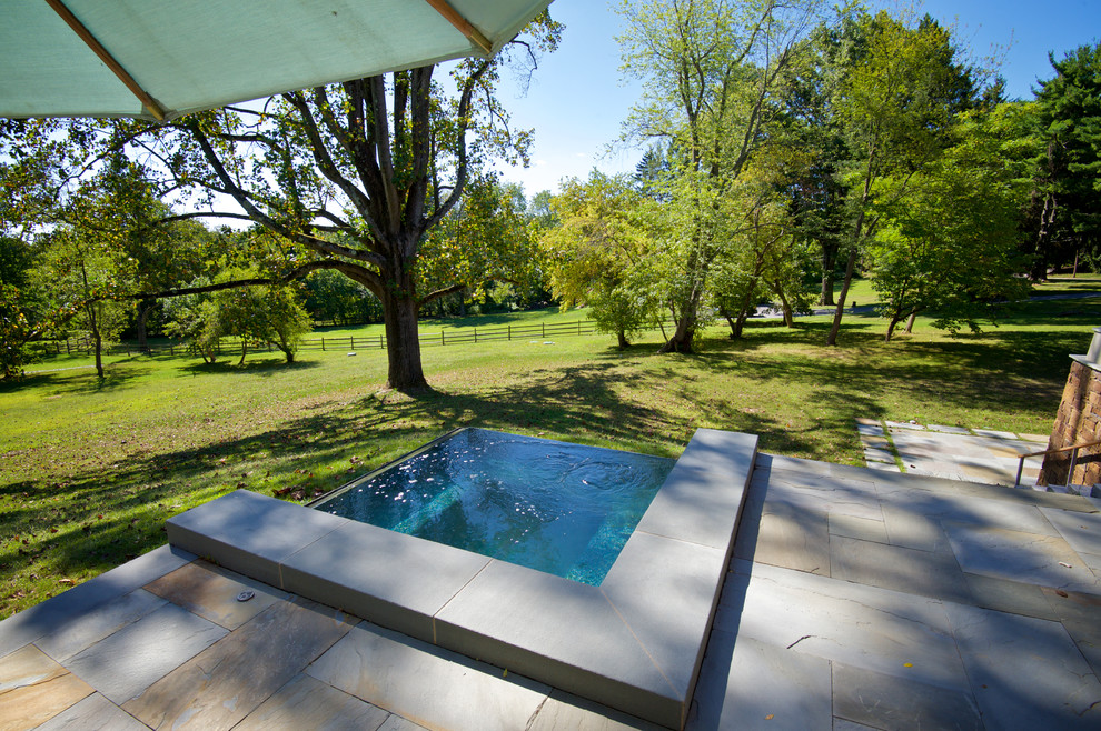 Ejemplo de piscinas y jacuzzis infinitos contemporáneos pequeños rectangulares en patio trasero con adoquines de piedra natural