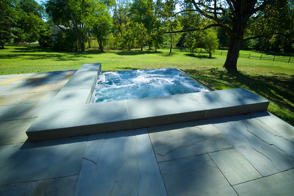 Пример оригинального дизайна: маленький прямоугольный бассейн-инфинити на заднем дворе в современном стиле с джакузи и покрытием из каменной брусчатки для на участке и в саду