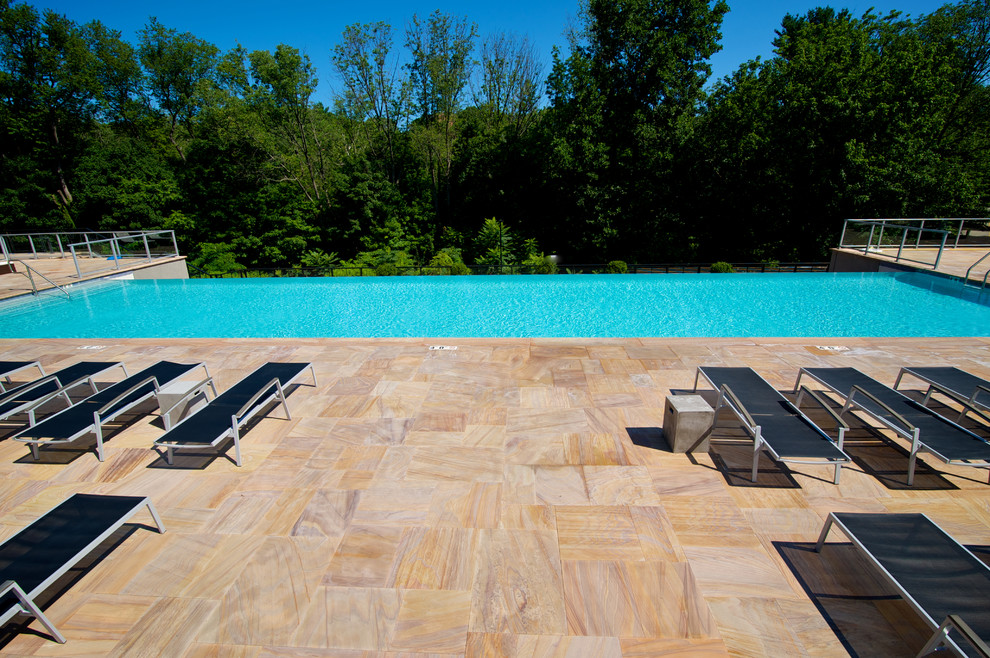 Foto de piscina con fuente infinita contemporánea extra grande rectangular en patio trasero con adoquines de piedra natural