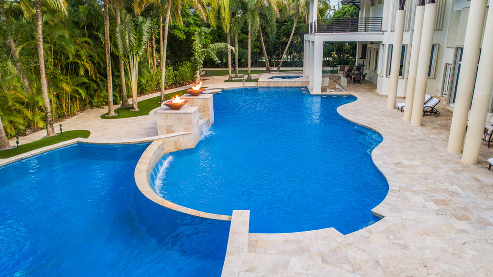 Ejemplo de piscina con fuente infinita moderna extra grande a medida en patio trasero con suelo de baldosas