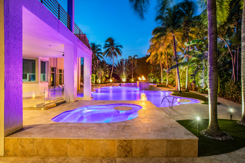 Idee per un'ampia piscina a sfioro infinito moderna personalizzata dietro casa con fontane e piastrelle