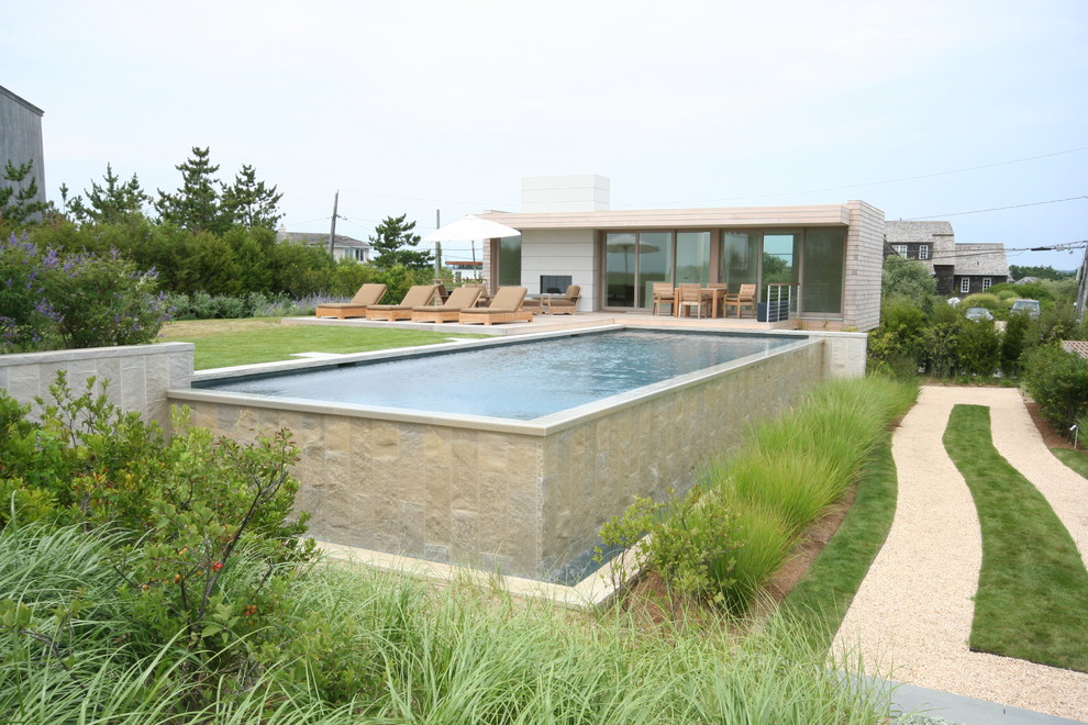 Пример оригинального дизайна: прямоугольный бассейн-инфинити на заднем дворе в морском стиле