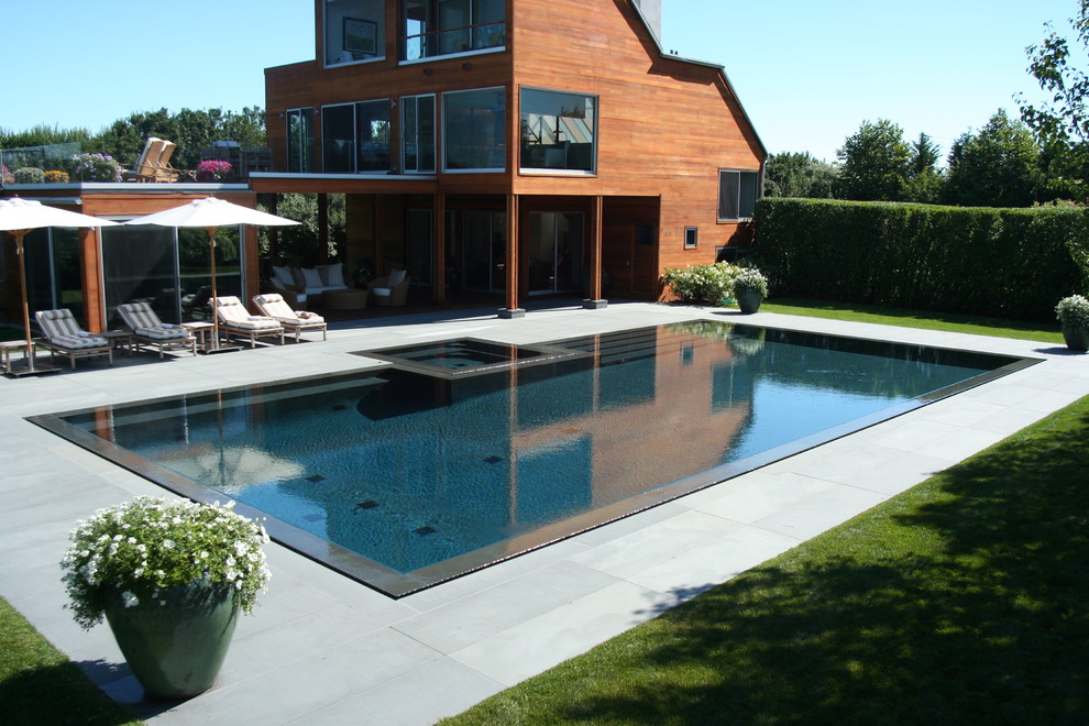 Ispirazione per una piscina contemporanea personalizzata con pavimentazioni in pietra naturale e una vasca idromassaggio