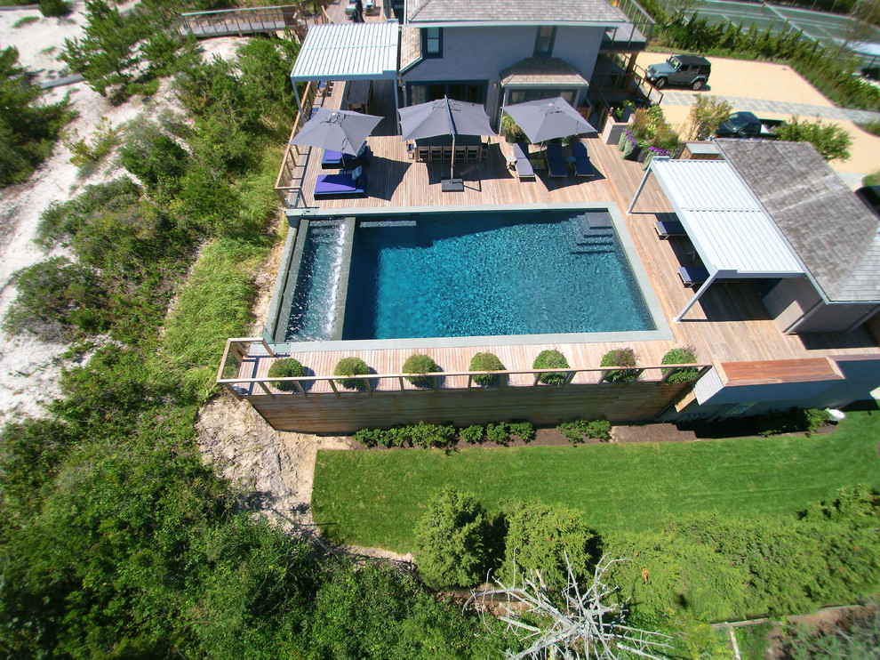 Imagen de piscinas y jacuzzis infinitos actuales rectangulares en patio lateral con entablado