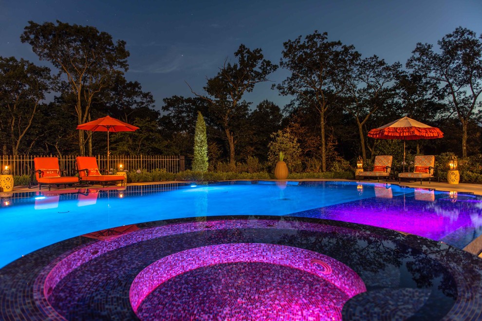 Geräumiger Mediterraner Infinity-Pool hinter dem Haus in individueller Form mit Wasserspiel und Natursteinplatten in New York