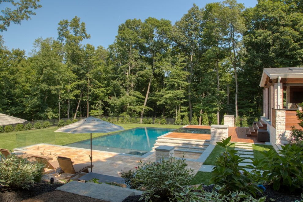 Inspiration pour une grande piscine à débordement et arrière minimaliste rectangle avec un point d'eau et des pavés en pierre naturelle.
