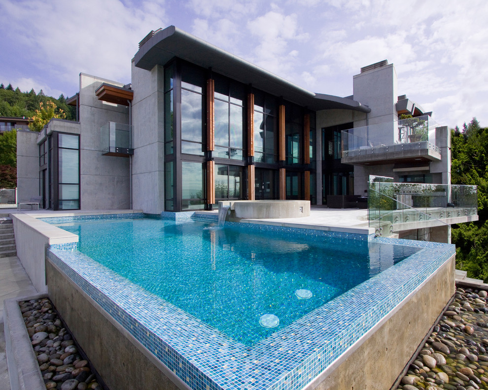 Eclectic infinity swimming pool in Vancouver with tiled flooring.