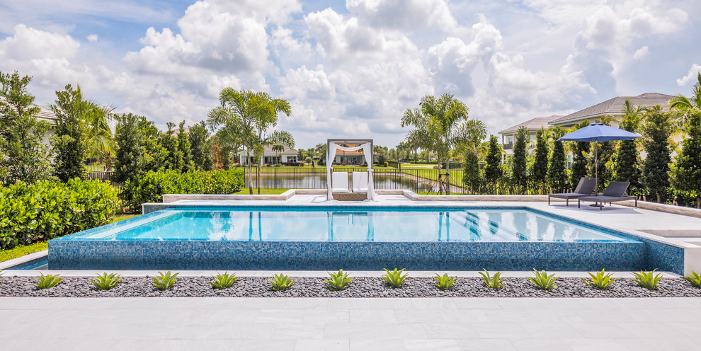 Diseño de piscina infinita moderna grande rectangular en patio trasero