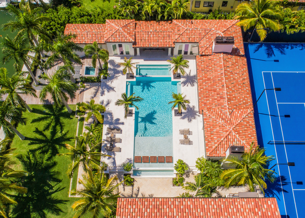 Huge minimalist backyard custom-shaped infinity hot tub photo in Miami