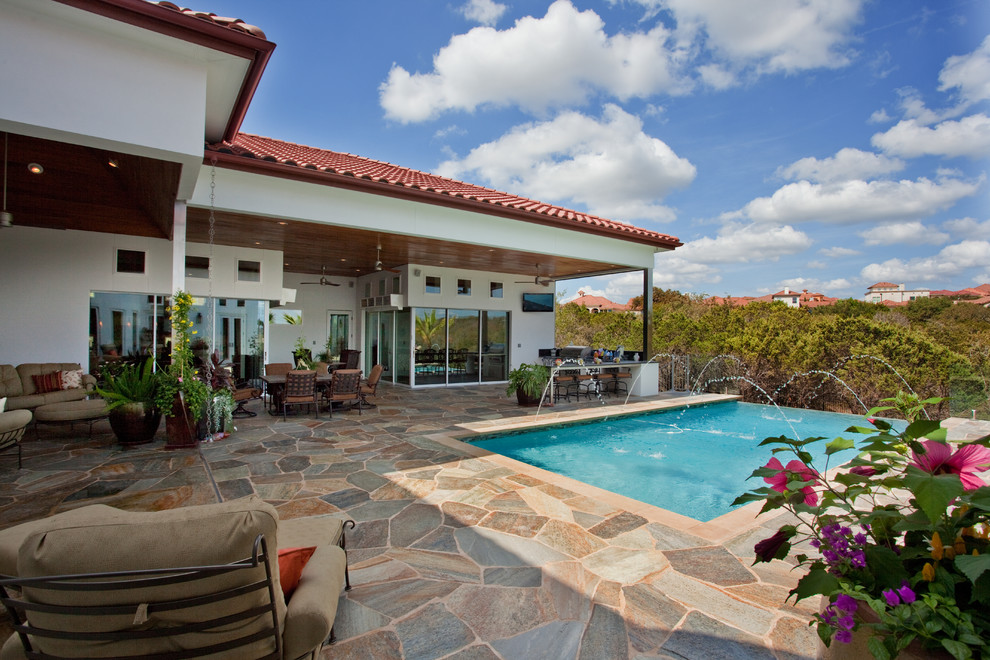 Diseño de piscina infinita rural de tamaño medio rectangular en patio trasero con adoquines de piedra natural