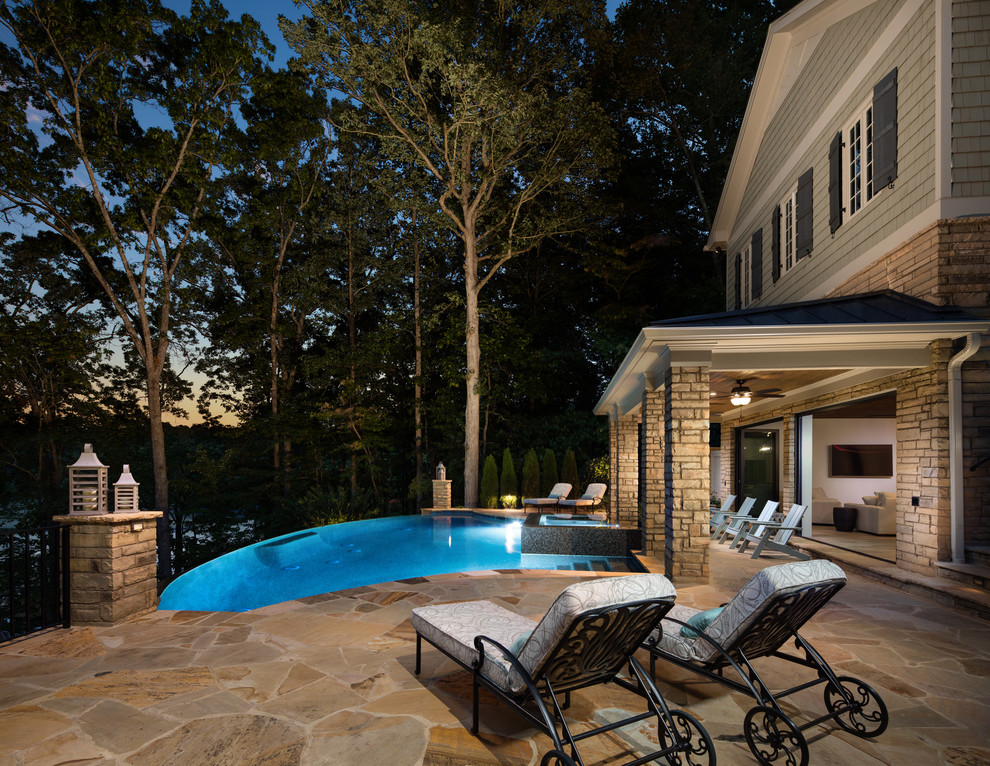 Идея дизайна: огромный бассейн-инфинити произвольной формы на заднем дворе в классическом стиле с домиком у бассейна и мощением клинкерной брусчаткой