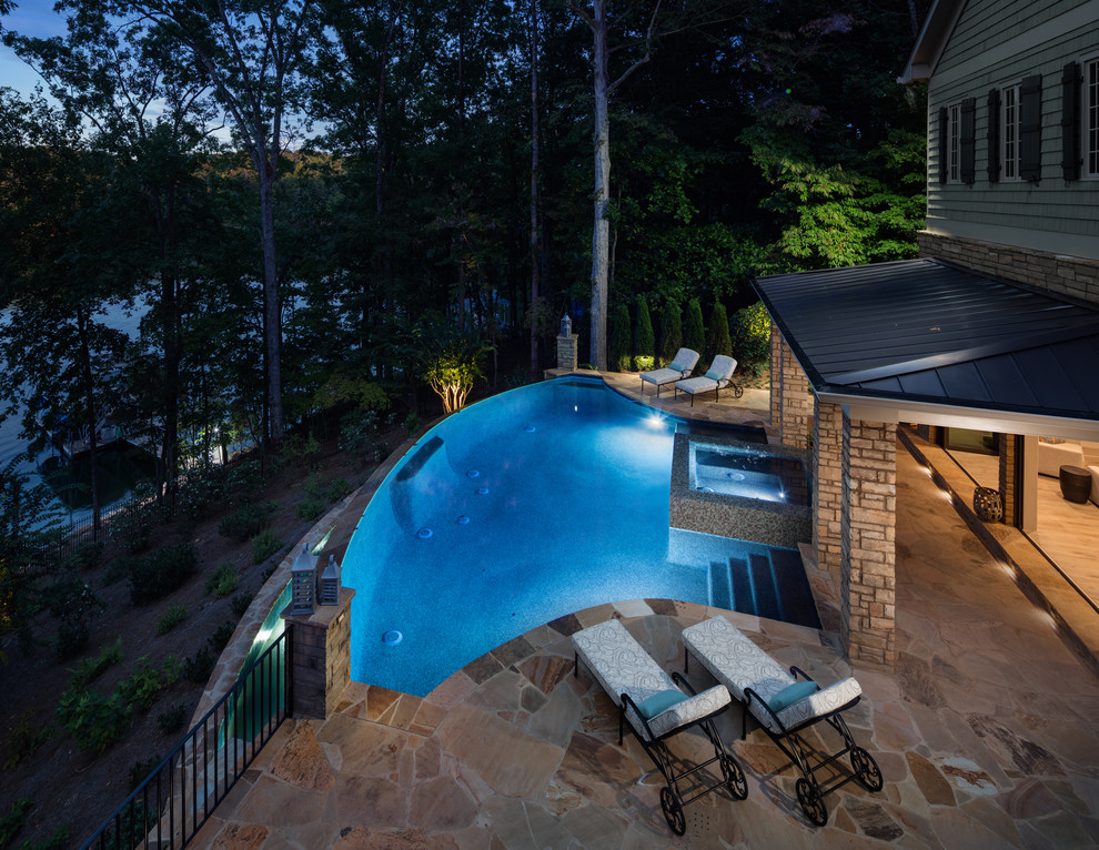 Ejemplo de casa de la piscina y piscina infinita clásica extra grande a medida en patio trasero con adoquines de ladrillo